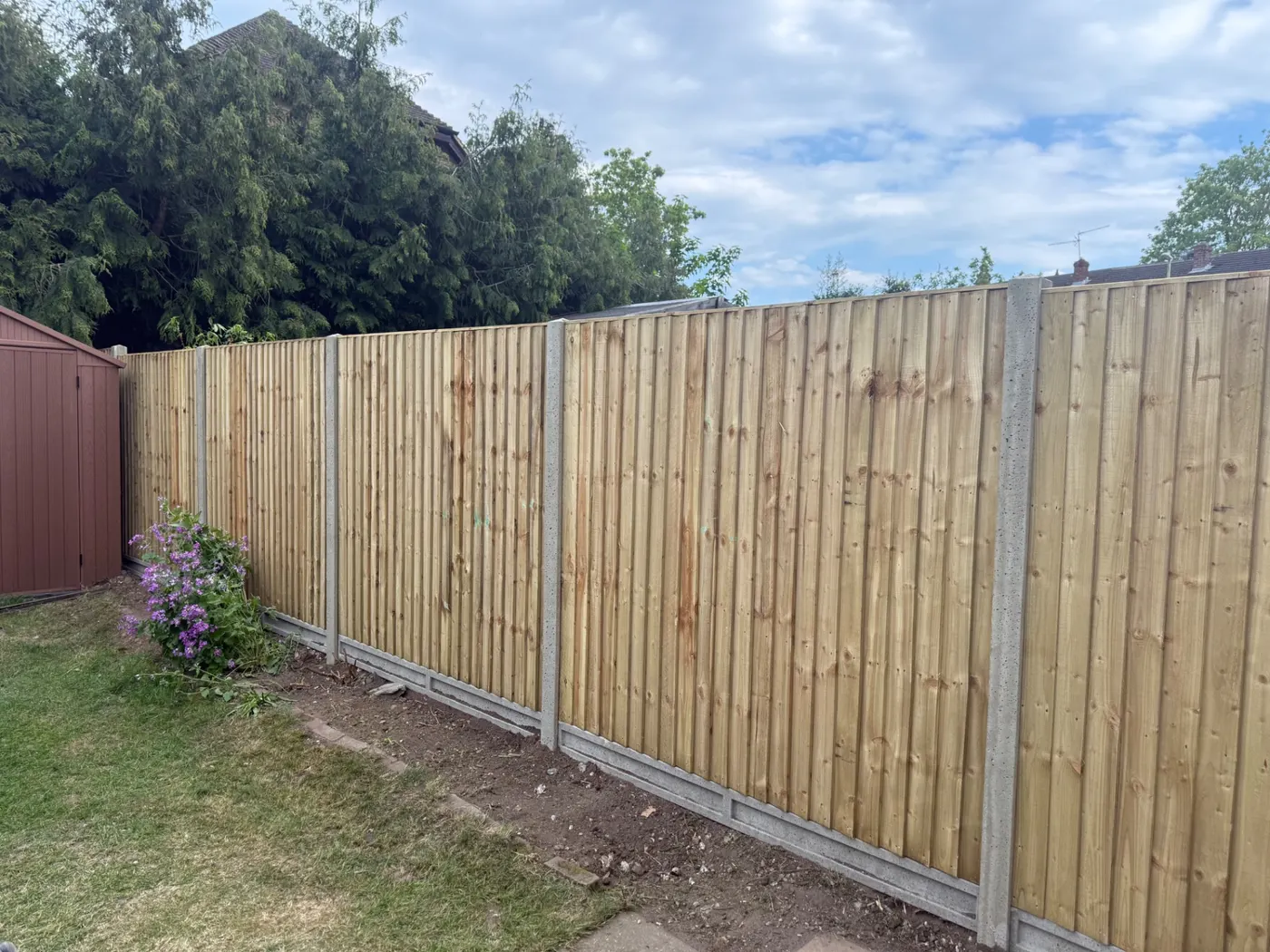 Long run of closeboard fence panels and gravel boards in a back garden